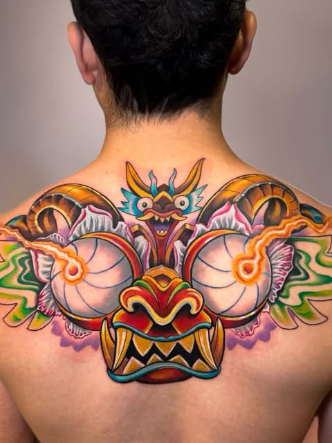 Dragón multicolor que ocupa la parte superior de la espalda